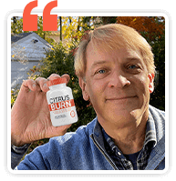 Satisfied Citrus Burn customer holding a bottle of metabolism support capsules in a verified user testimonial.